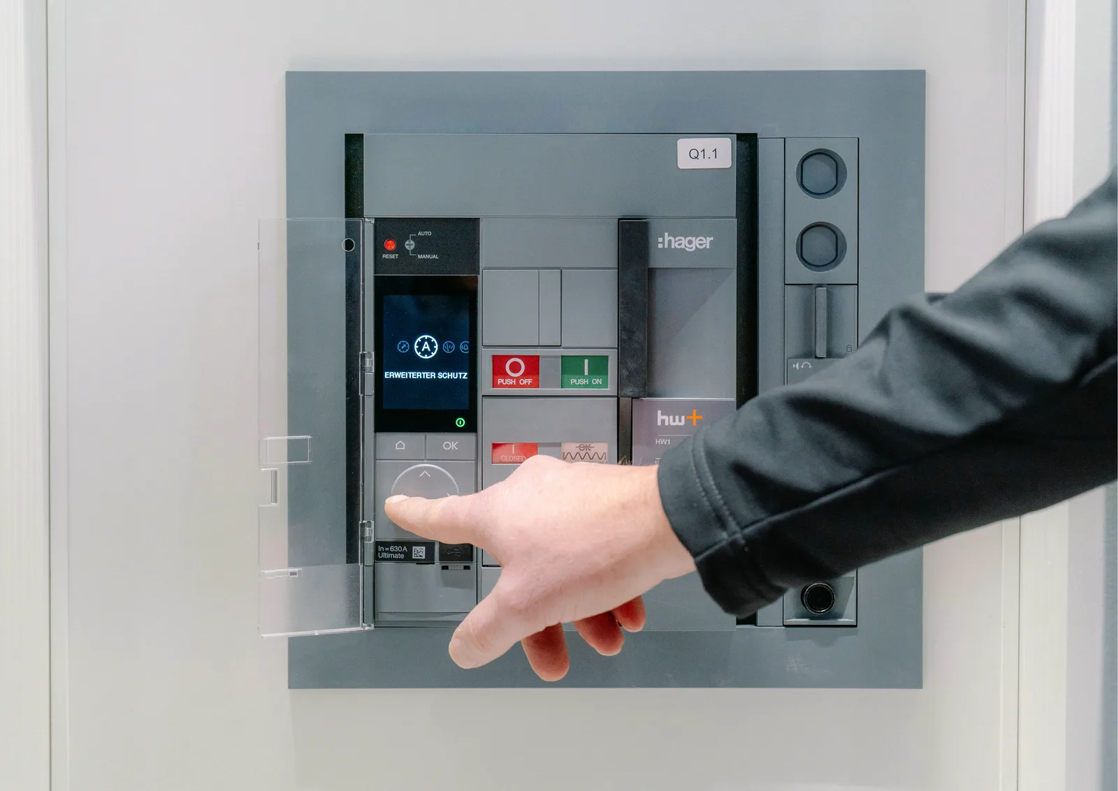 Hand bedient einen Leistungsschalter im Verteilerschrank