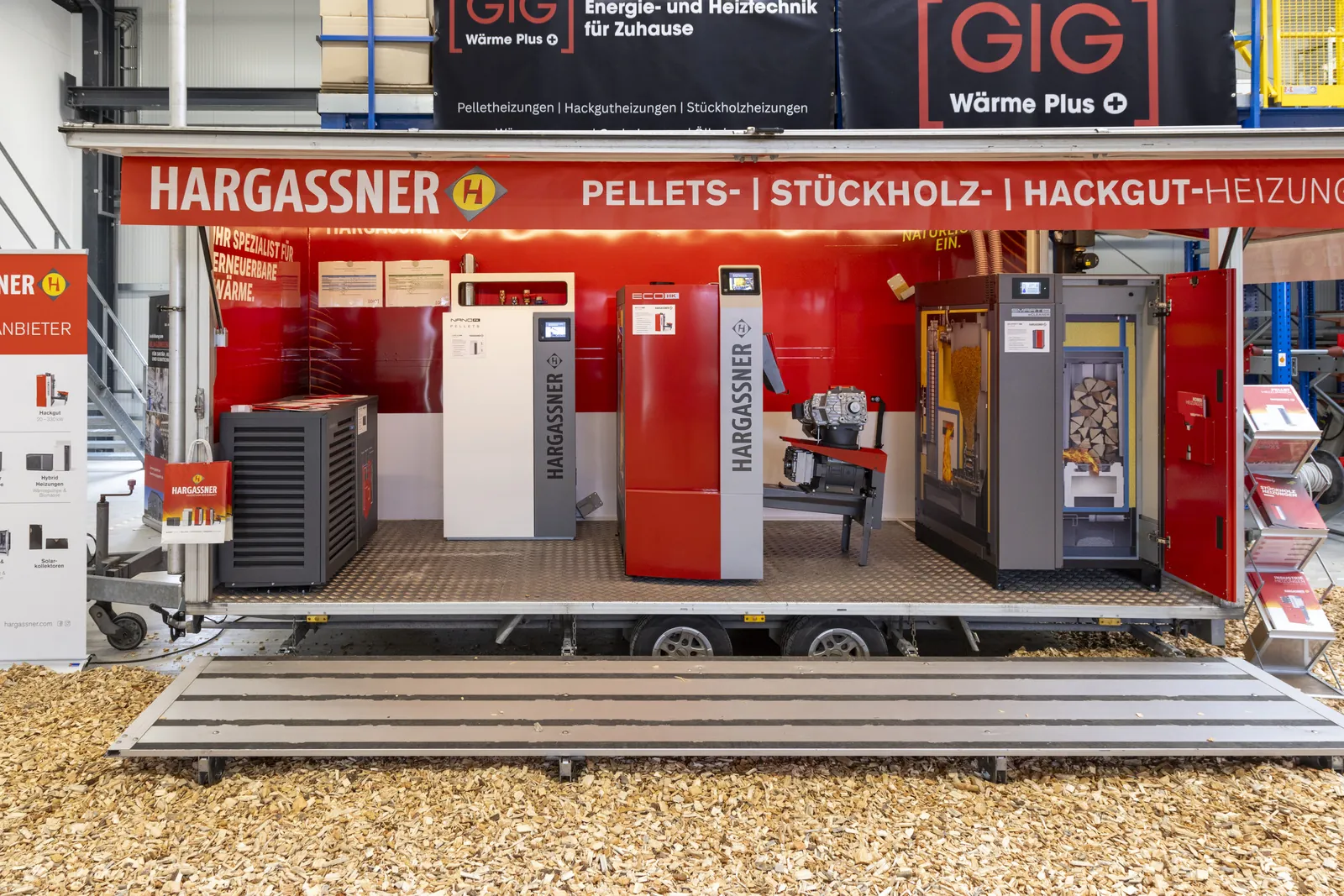 Ausstellungsanhänger mit Pellet-, Stückholz- und Hackgutkesseln, rechts ein Kessel mit eingelegtem Scheitholz
